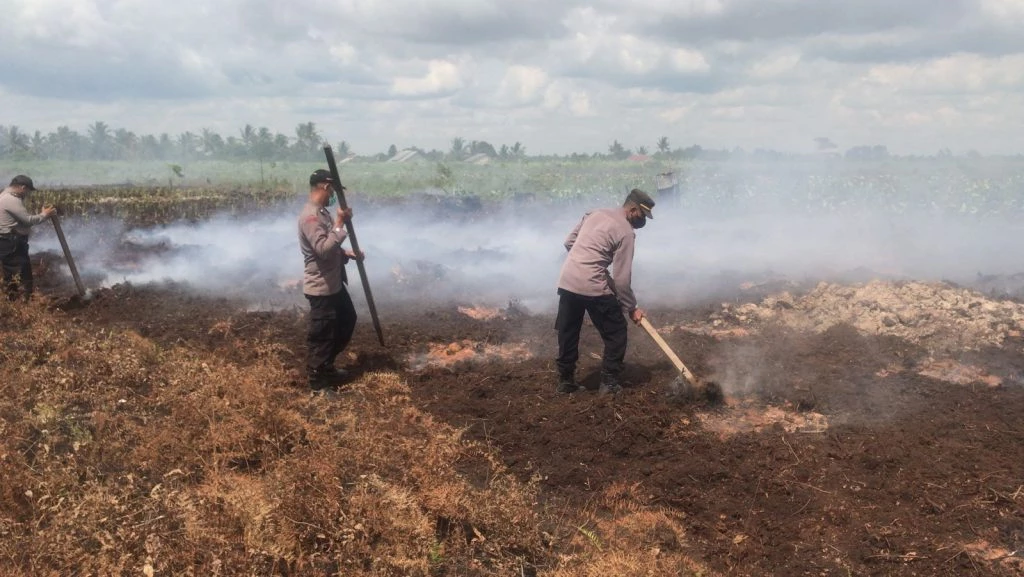 Foto: Kapolsek Sungai Kakap Beserta Personel Turun Langsung Tangani Karhutla di Desa Punggur Kecil, Kubu Raya       | Pifa Net